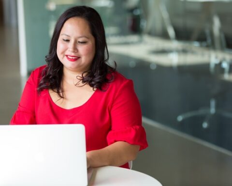A female professional researching knowledge management tools on a laptop, actively evaluating the best options for her organization